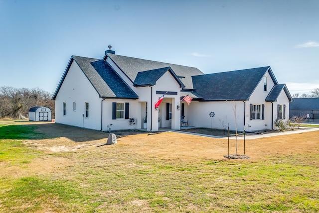 modern inspired farmhouse featuring a front lawn and a shed