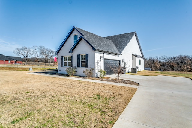 view of home's exterior featuring a lawn, central AC unit, and a garage