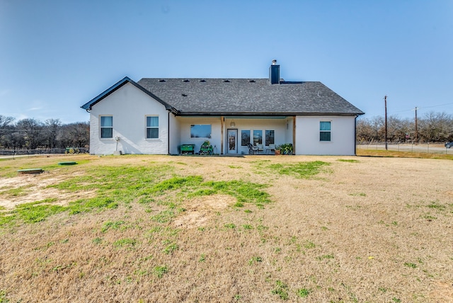 rear view of house with a yard