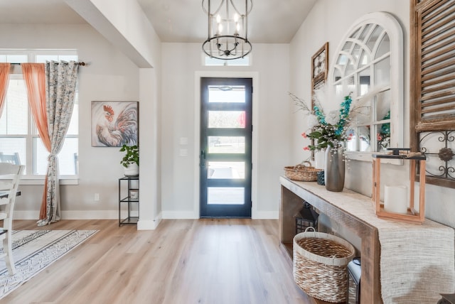 entryway with light wood-type flooring and a notable chandelier