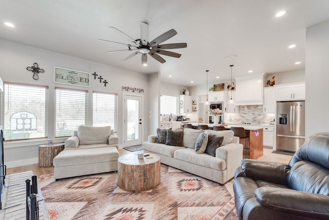 living room with light wood-type flooring and ceiling fan