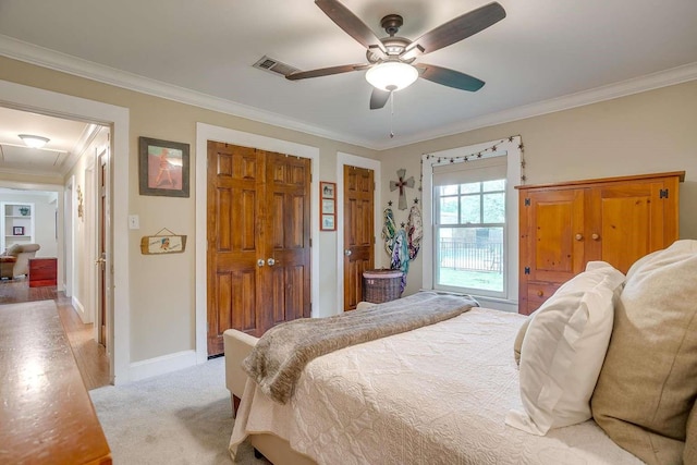 bedroom with ceiling fan, crown molding, and light carpet