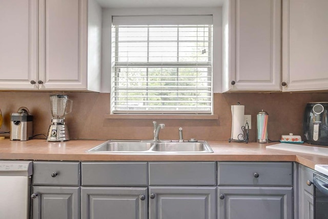 kitchen featuring white cabinetry, sink, tasteful backsplash, white dishwasher, and gray cabinets