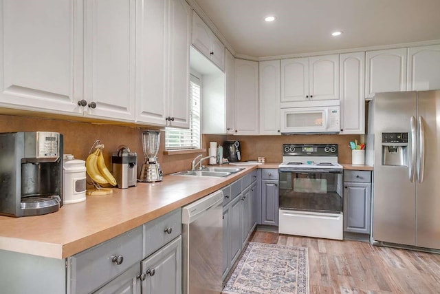 kitchen featuring gray cabinets, sink, white cabinets, and white appliances