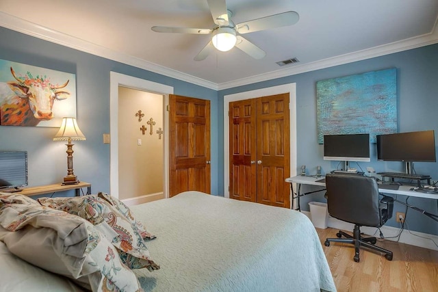 bedroom with hardwood / wood-style flooring, ceiling fan, crown molding, and a closet