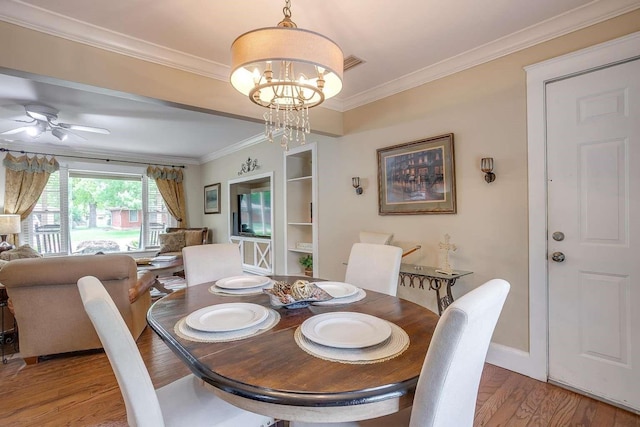 dining space with ceiling fan with notable chandelier, light hardwood / wood-style flooring, and crown molding