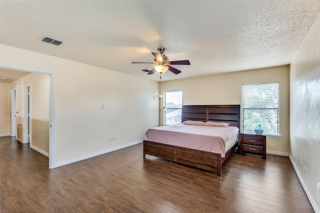 bedroom featuring ceiling fan, dark hardwood / wood-style flooring, and a textured ceiling