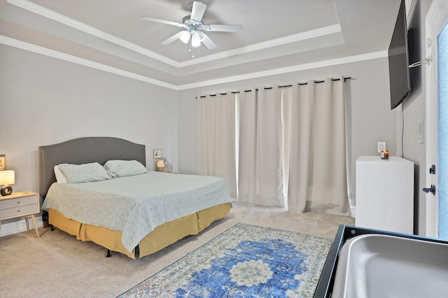 bedroom featuring light carpet, ornamental molding, a tray ceiling, ceiling fan, and sink