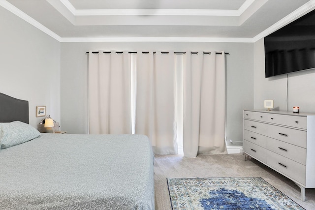 bedroom with crown molding, light carpet, and a tray ceiling