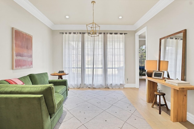 living area with light wood-type flooring, crown molding, and a notable chandelier