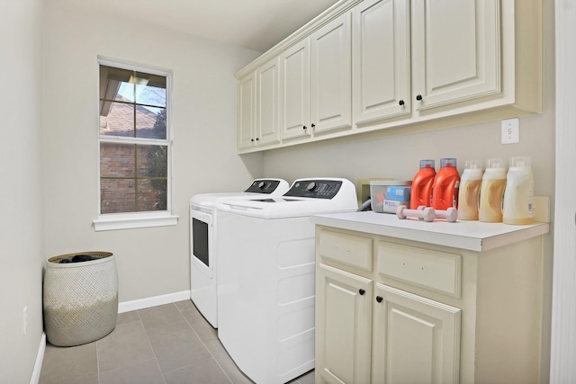 clothes washing area featuring washer and dryer, light tile patterned floors, and cabinets