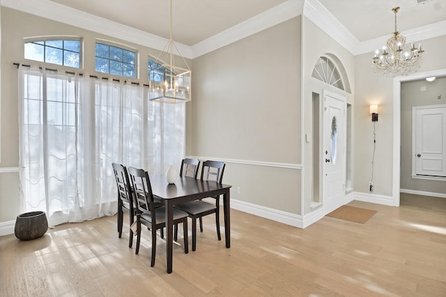 dining room with light hardwood / wood-style flooring, an inviting chandelier, and crown molding