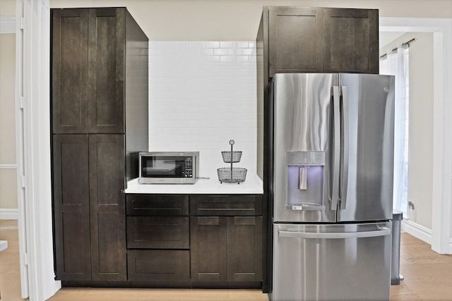 kitchen featuring dark brown cabinetry, stainless steel appliances, and light hardwood / wood-style flooring