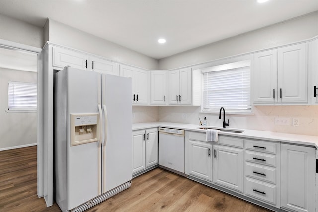 kitchen featuring white cabinetry, white appliances, and sink