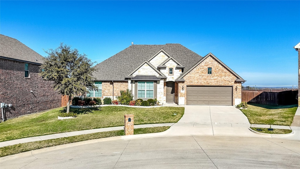 view of front of home with a garage and a front lawn