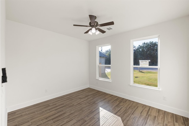 empty room with ceiling fan and dark hardwood / wood-style flooring