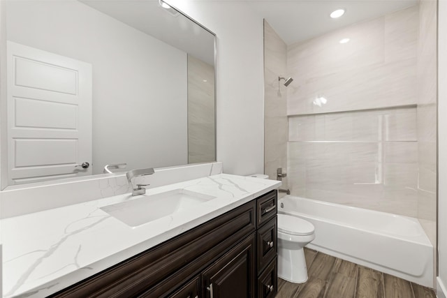 full bathroom featuring toilet, hardwood / wood-style floors, vanity, and washtub / shower combination