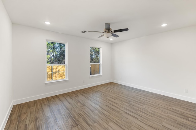 empty room with ceiling fan and light hardwood / wood-style floors