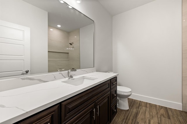 bathroom featuring vanity, toilet, and walk in shower