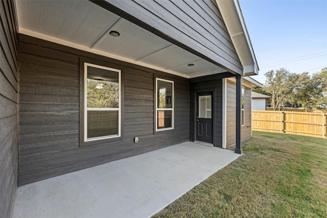 property entrance featuring a lawn and a patio area