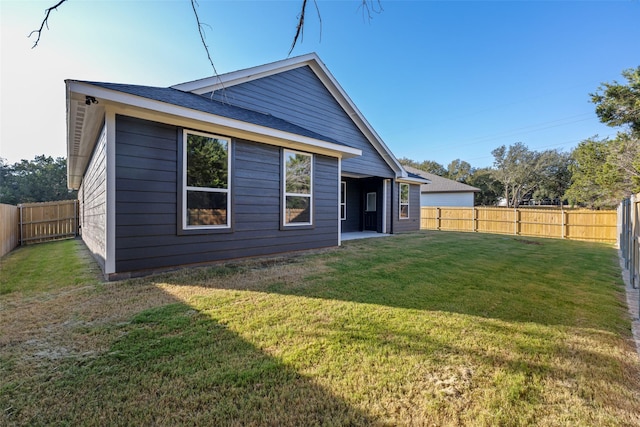 back of property featuring a yard