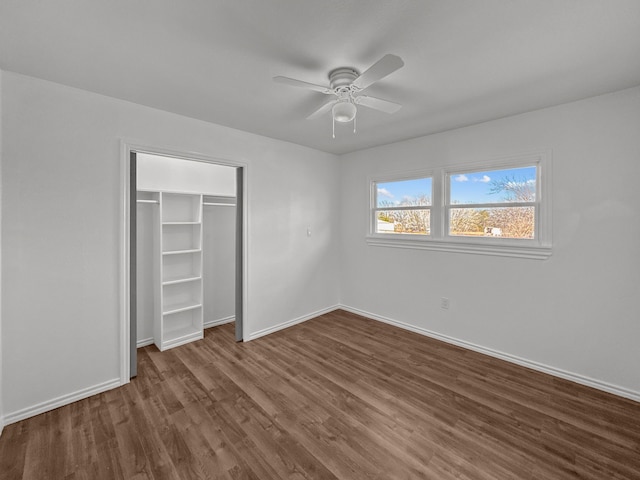 unfurnished bedroom featuring dark wood-type flooring, ceiling fan, and a closet