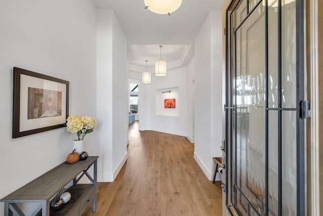 entryway with a tray ceiling and light hardwood / wood-style flooring