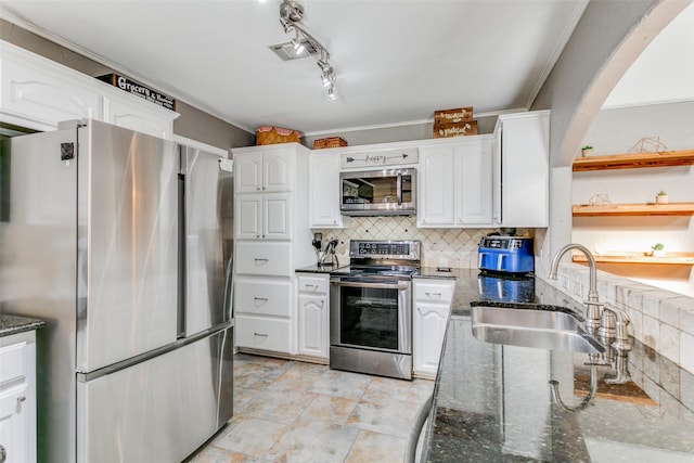 kitchen with white cabinetry, stainless steel appliances, sink, and dark stone counters