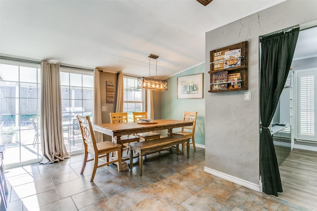 dining area with expansive windows, ornamental molding, and vaulted ceiling