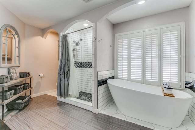 bathroom featuring separate shower and tub