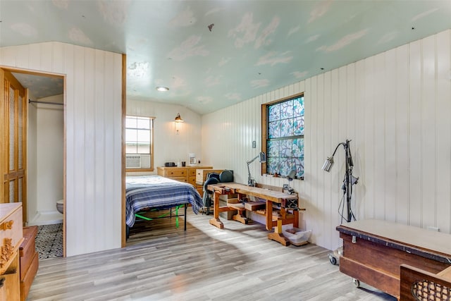 bedroom with vaulted ceiling, light hardwood / wood-style floors, and multiple windows