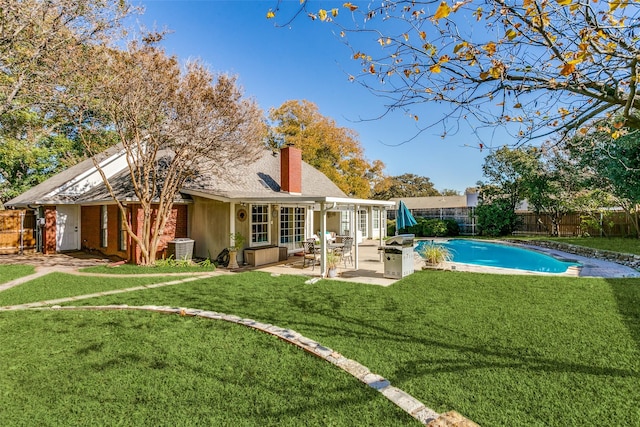 back of house with a fenced in pool, a yard, cooling unit, and a patio area