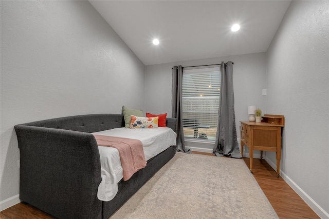 bedroom with lofted ceiling and hardwood / wood-style flooring