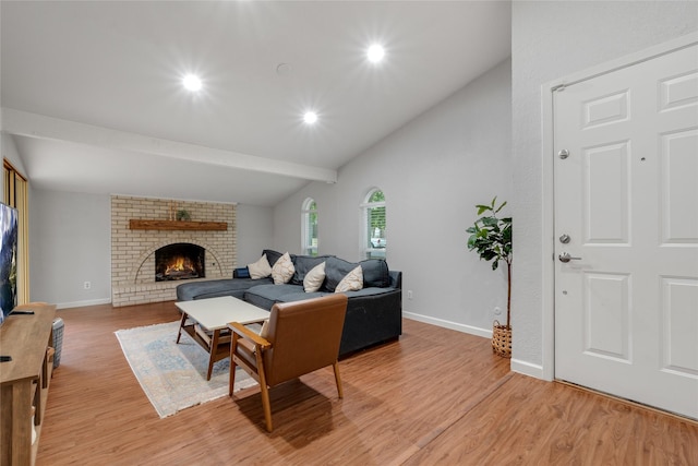 living room with lofted ceiling, light wood-type flooring, and a fireplace