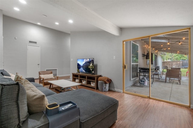 living room featuring wood-type flooring and vaulted ceiling with beams