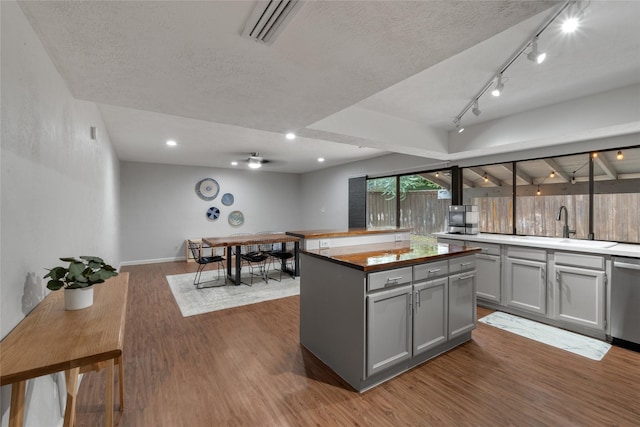 kitchen featuring sink, gray cabinetry, dark hardwood / wood-style floors, dishwasher, and a kitchen island