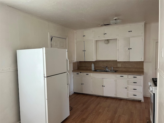 kitchen featuring white cabinetry, sink, dark hardwood / wood-style floors, and white fridge