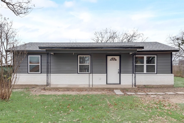 single story home featuring a porch and a front lawn