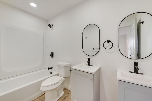 full bathroom featuring vanity, hardwood / wood-style floors, toilet, and washtub / shower combination