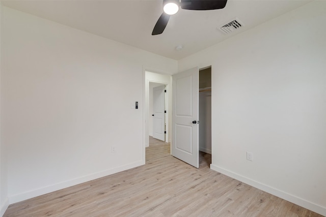 unfurnished bedroom featuring light hardwood / wood-style flooring, a closet, and ceiling fan