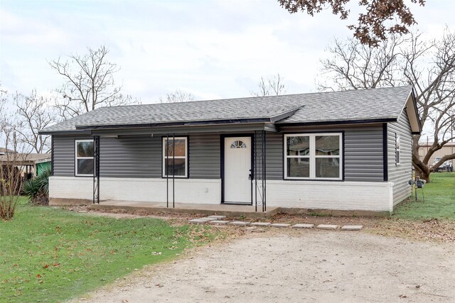 ranch-style house with covered porch and a front yard