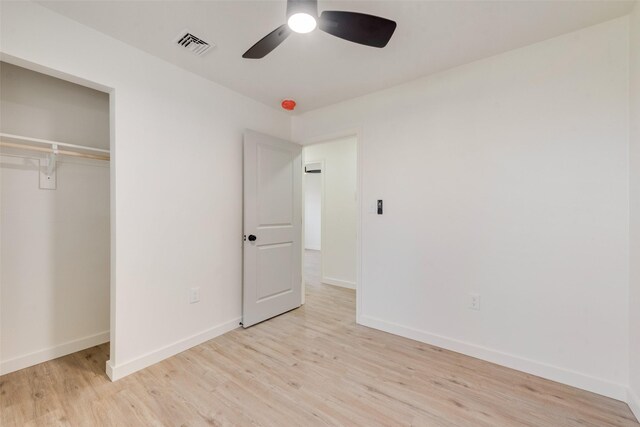 unfurnished bedroom featuring light hardwood / wood-style floors, a closet, and ceiling fan