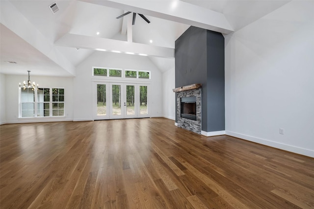 unfurnished living room with dark wood-type flooring, high vaulted ceiling, ceiling fan with notable chandelier, a fireplace, and beamed ceiling