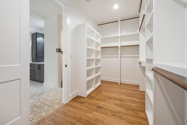 spacious closet with light hardwood / wood-style flooring