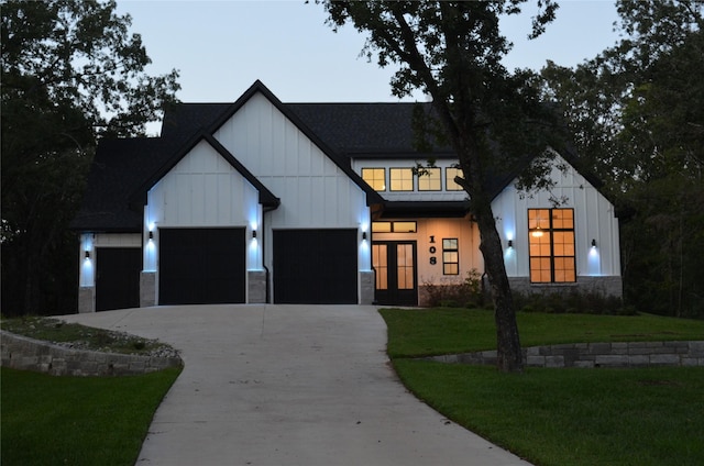 modern farmhouse style home featuring a yard and a garage