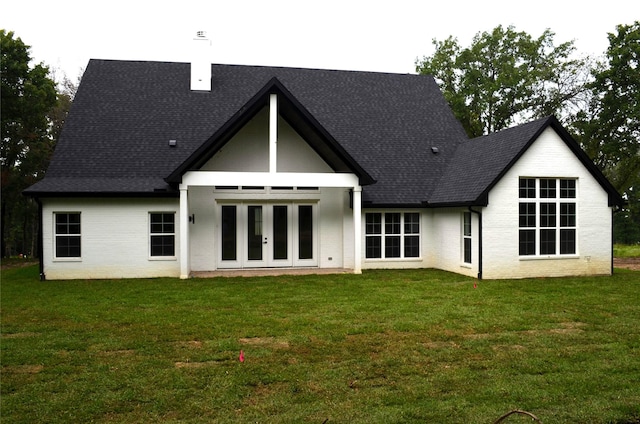 back of property featuring a lawn and french doors