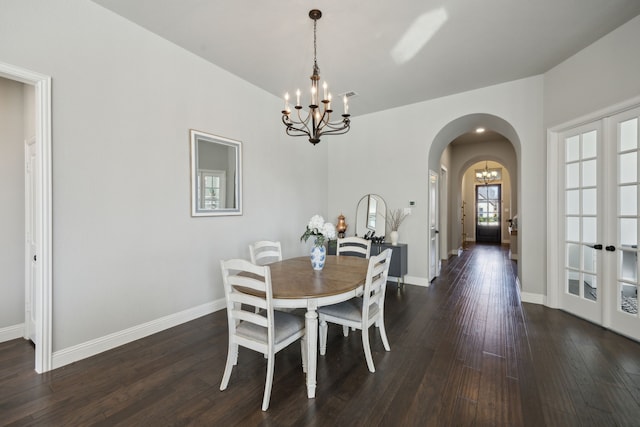 dining room featuring dark hardwood / wood-style flooring, an inviting chandelier, and french doors