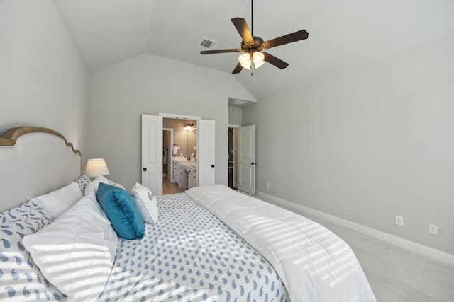 bedroom featuring ceiling fan, lofted ceiling, connected bathroom, and light carpet