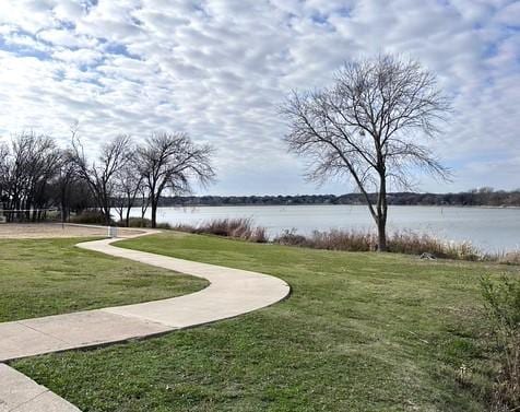 view of home's community with a lawn and a water view