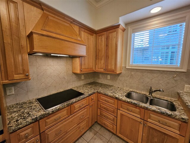 kitchen featuring sink, black electric stovetop, dark stone counters, and custom exhaust hood